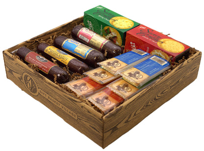 Charcuterie basket gift box with salami, crackers, and cheese packs in an open wooden crate