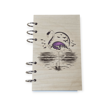 Closed A6 wood notebook journal with purple flamingo cover art and metal ring binding