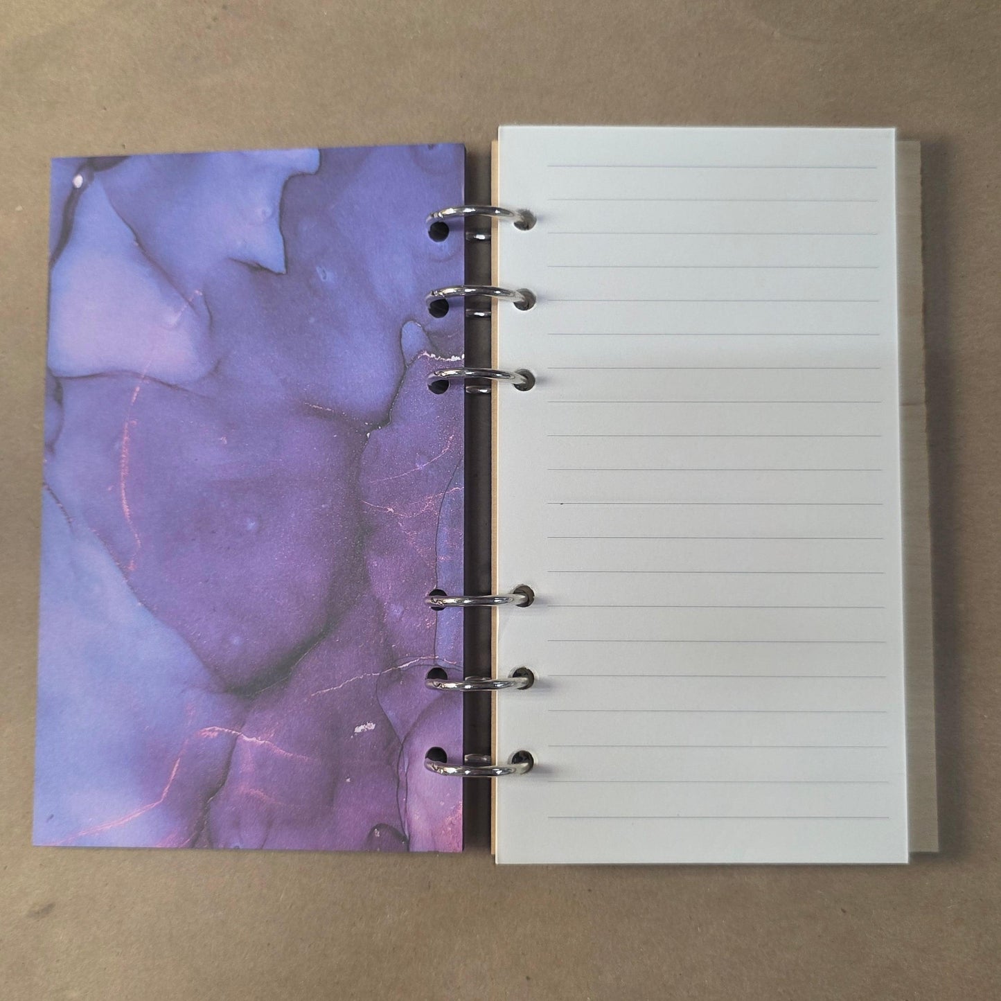 Refillable notebook journal with open lined pages and purple abstract left insert
