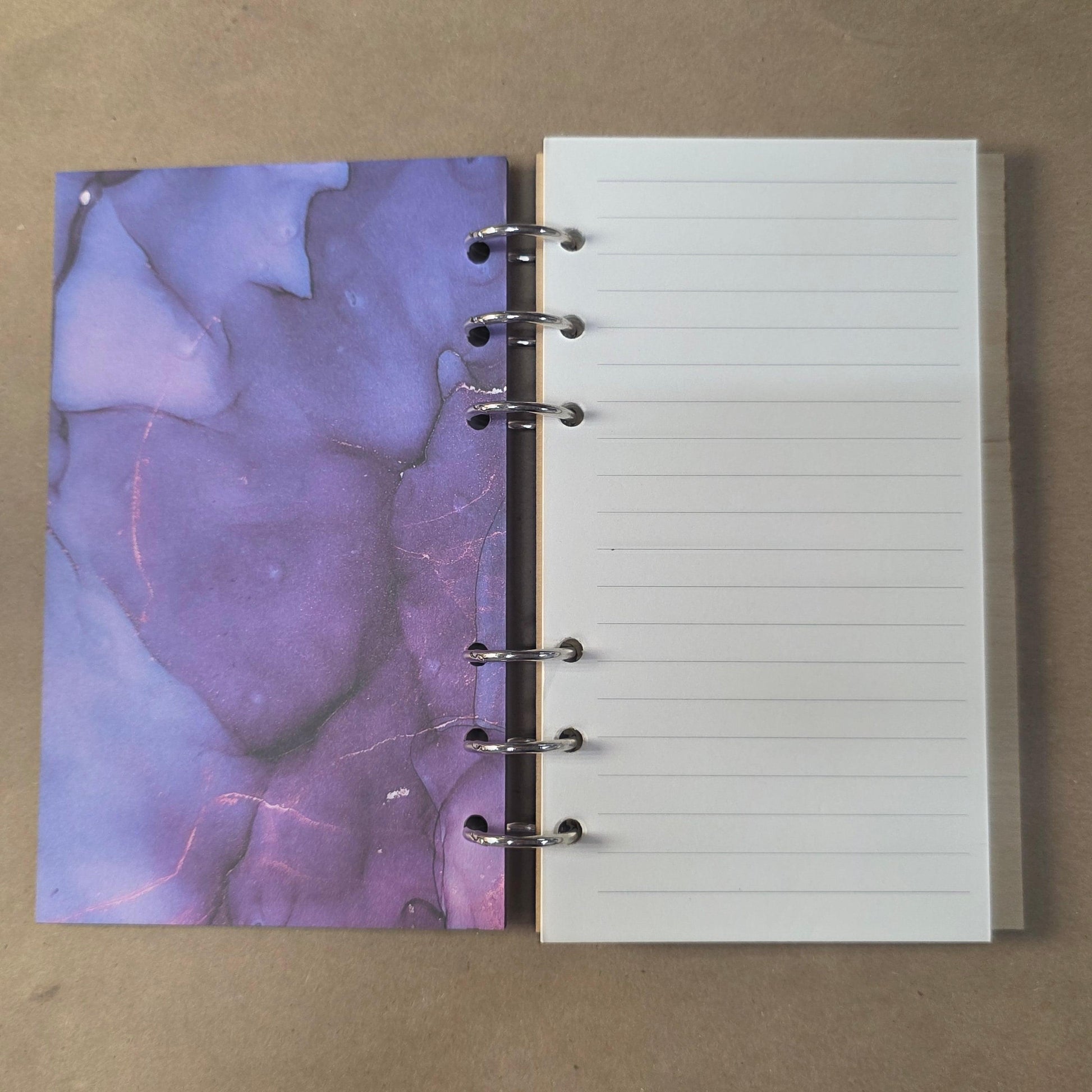 Refillable notebook journal with open lined pages and purple abstract left insert