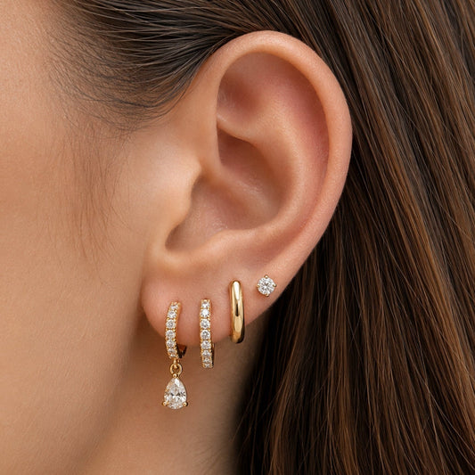 Gold huggie hoop earrings with pavé stones and a teardrop charm
