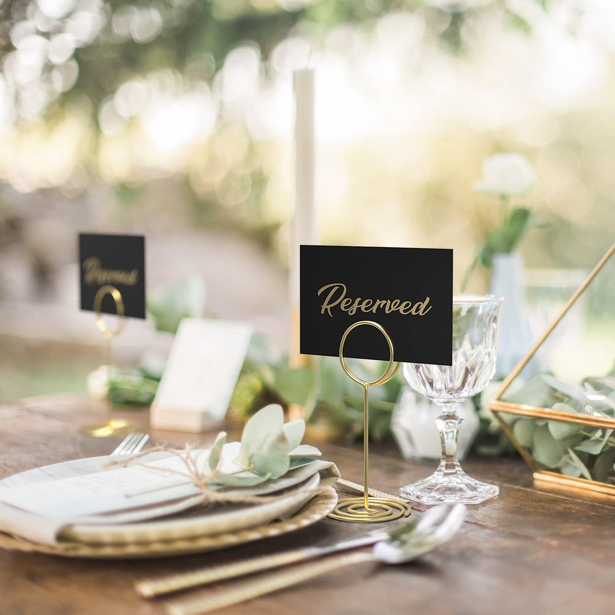 Black tent card with gold-foil “Reserved” on a dining table