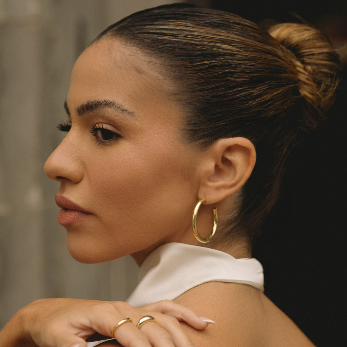 Gold-filled 30mm hoop earrings on ear, polished gold round hoop
