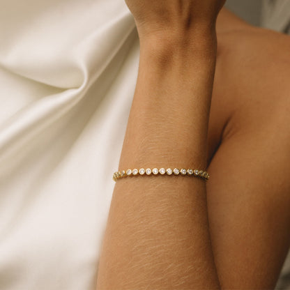 Gold filled bracelet with evenly spaced round diamond bezels along the chain