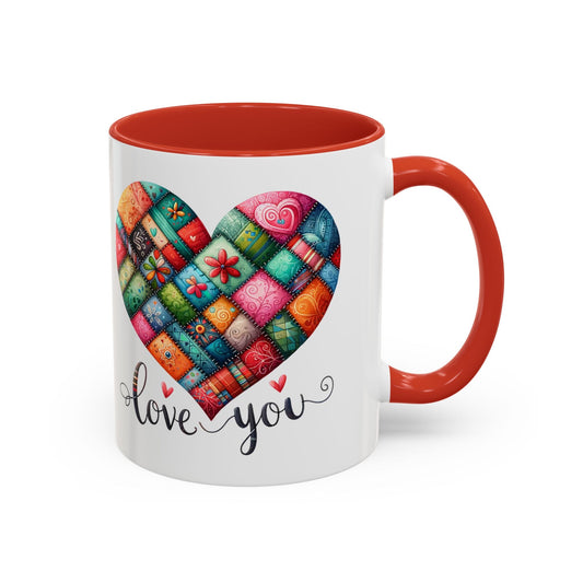 White coffee mug with colorful quilt heart print, love you text, orange rim and handle.