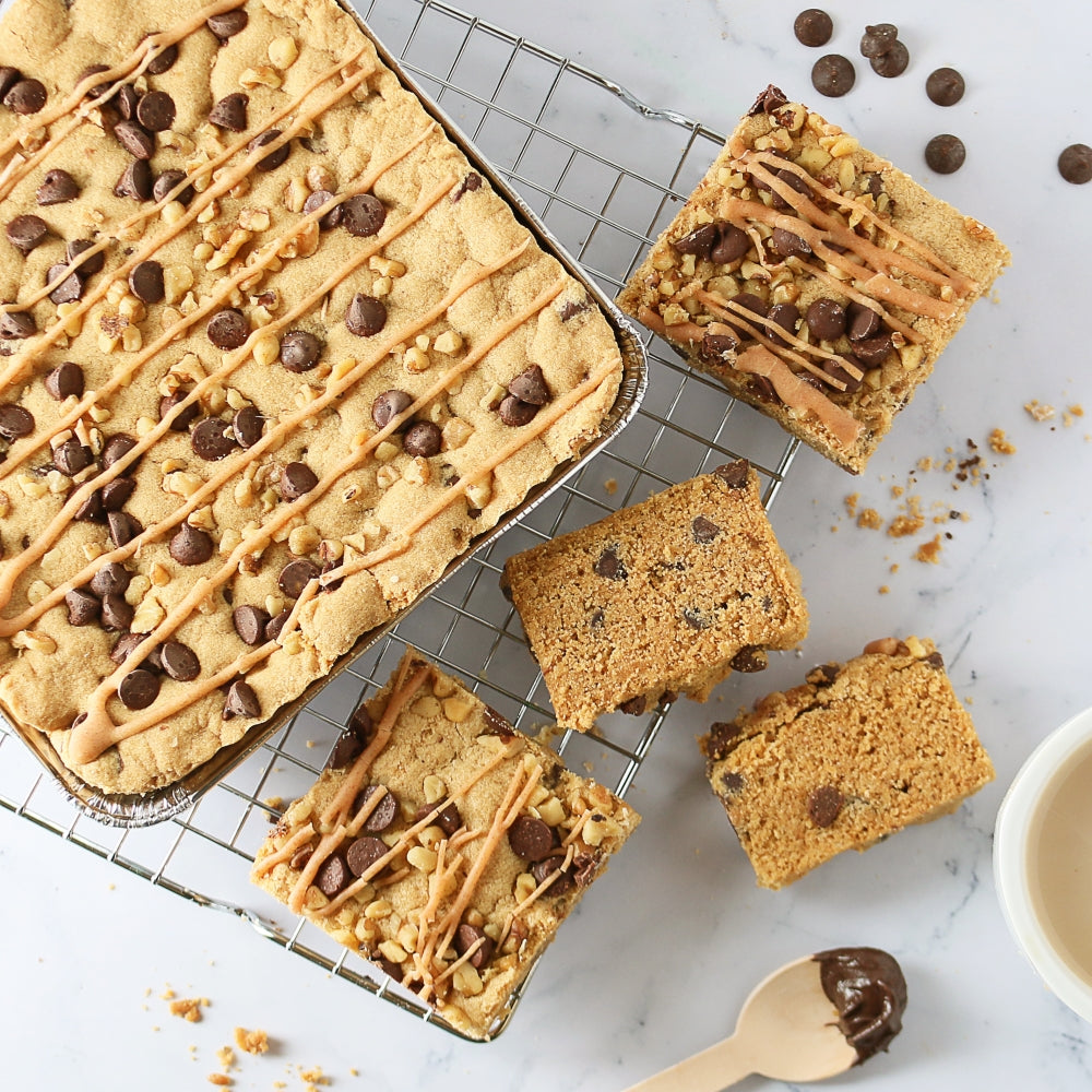 Assorted brownie bars on a cooling rack with chocolate chip and drizzle toppings