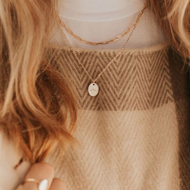 Gold-filled paperclip necklace layered above a fine pendant chain.