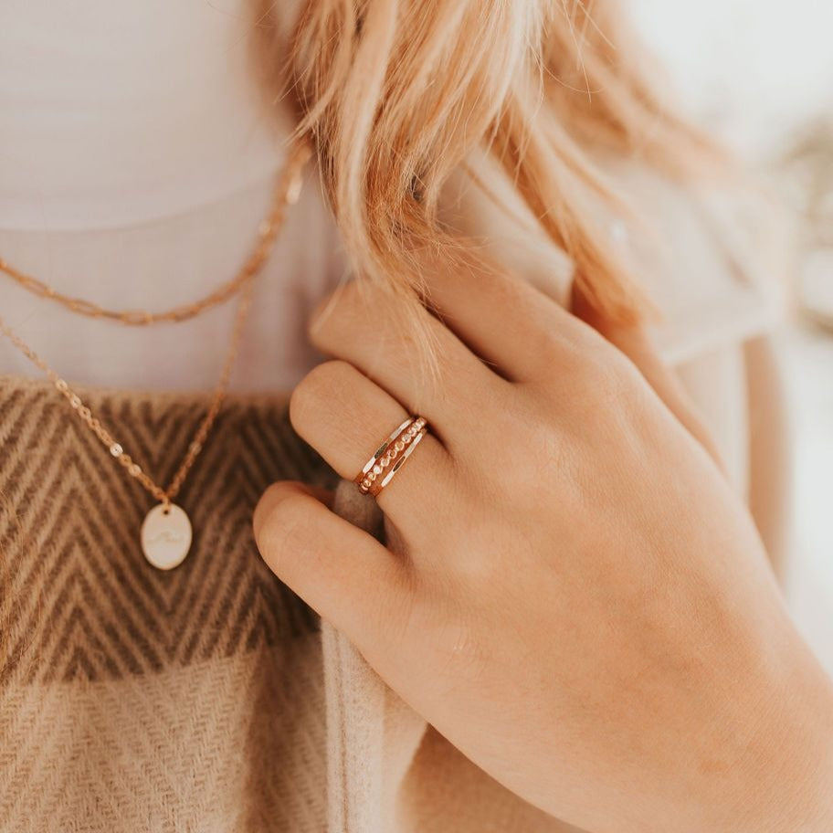 Gold filled stacking ring worn with a textured band and a slim beaded band.