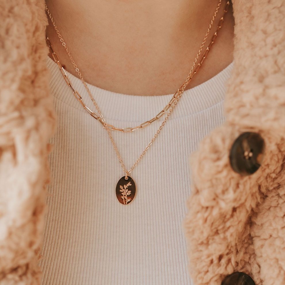 Gold-filled paperclip necklace layered with a floral medallion pendant.