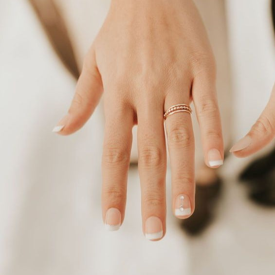 Gold filled stacking ring shown as slim textured and beaded bands stacked together.