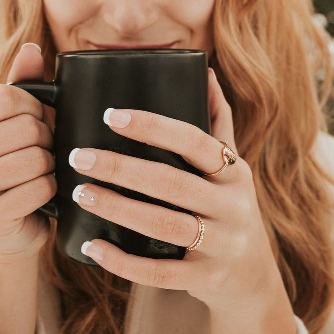 Gold filled stacking ring with a delicate beaded band, worn below a gold ring.