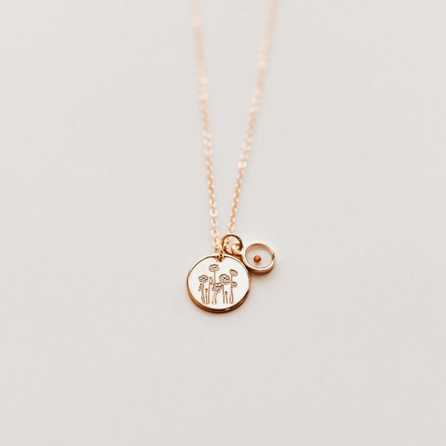 Gold-tone poppy necklace with engraved round pendant and mustard seed charm