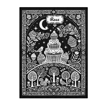 Coloring blanket with black background and white cupcake, bird, and tree doodle pattern