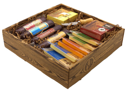 Wood gift basket with cheeses, sausages, and assorted packaged snacks