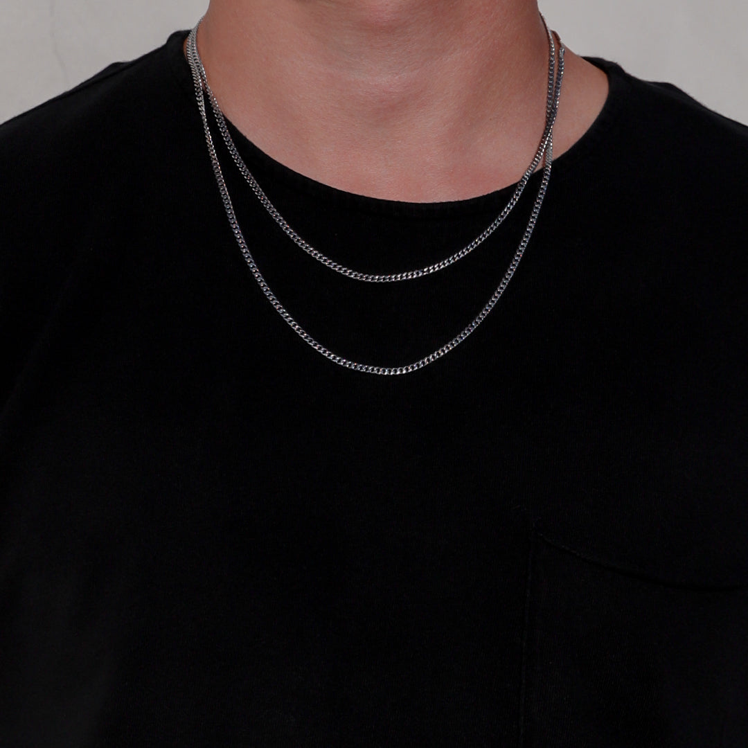 Single silver-tone Miami Cuban link chain necklace on a black crewneck