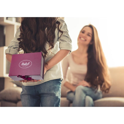 Child holding Dulcet gift box with ribbon in front of a smiling recipient
