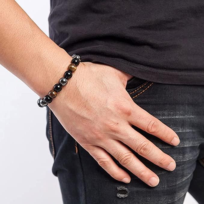 Black and brown beaded bracelet worn on wrist with glossy stone beads and hematite accents