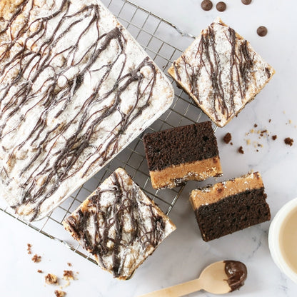 Tray of sliced brownies and chocolate bars with powdered icing