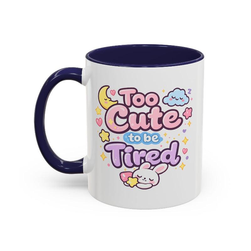 White mug with navy rim and handle, kawaii bunny “Too Cute to be Tired” graphic.