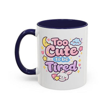 White mug with navy rim and handle, kawaii bunny “Too Cute to be Tired” graphic.