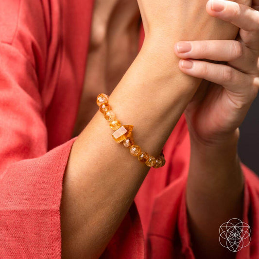 Citrine bracelet on wrist with round amber beads and a pointed crystal centerpiece
