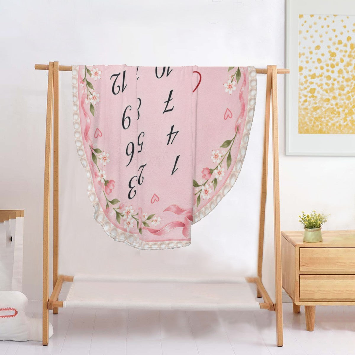 Pink round milestone blanket on stand with floral trim, numbers 1-12 and Charlotte