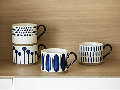 Four white porcelain mugs with navy line and dot patterns and black handles