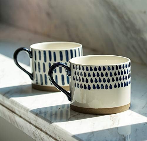 Pair of blue patterned porcelain mugs with black handles on a marble tray