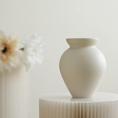 Cream ceramic milk can vase with matte speckled finish, flared rim and bulbous body.