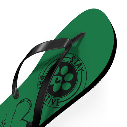 Green flip-flop close-up with black toe thong and paw-print logo on strap