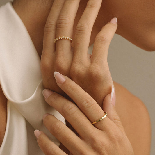 Gold half-eternity ring with small cubic zirconia stones on finger