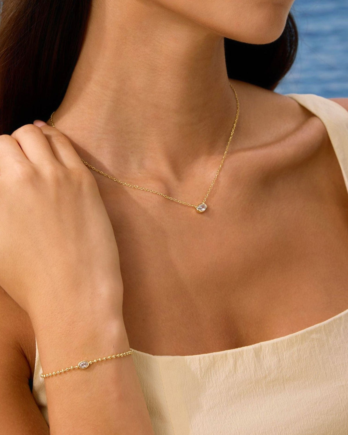 Gold-filled oval diamond pendant necklace on thin chain, close-up detail