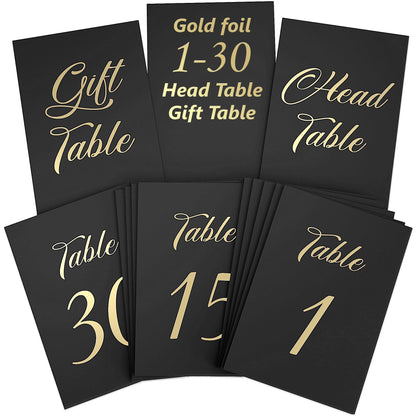 Black table cards with gold foil “1–30 Head Table,” “Gift Table,” and number designs