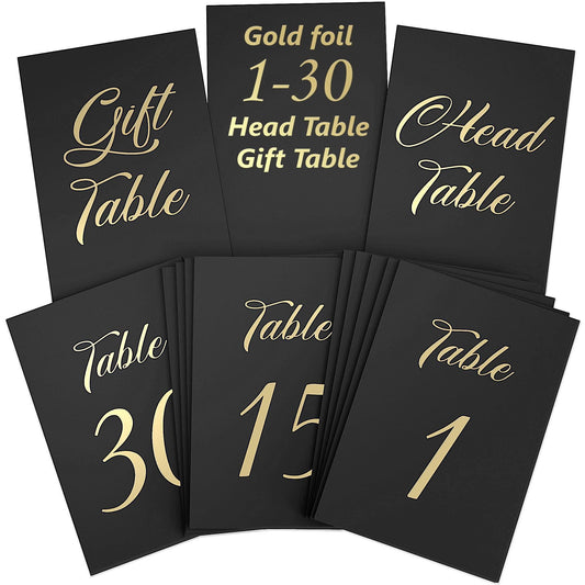 Black table cards with gold foil “1–30 Head Table,” “Gift Table,” and number designs
