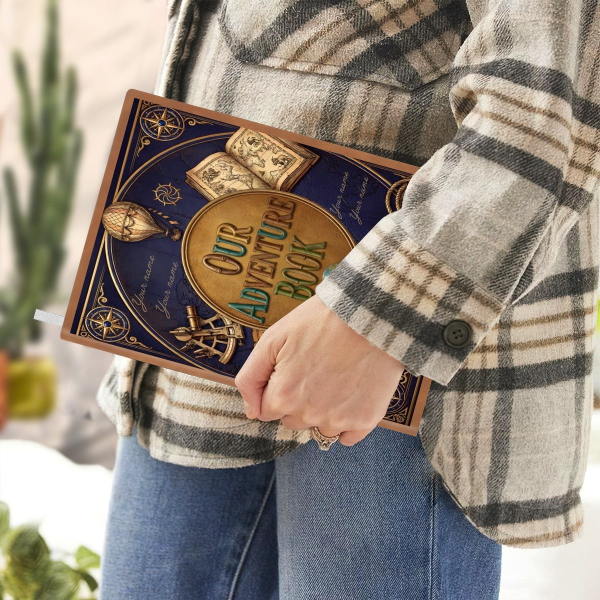 Navy adventure notebook held in hand with gold “Our Adventure Book” cover
