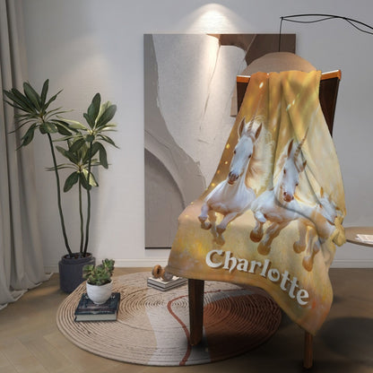 Unicorn name blanket draped on chair with three white horses and name Charlotte