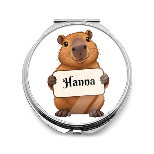 Silver compact mirror with a capybara holding a blank sign on the cover