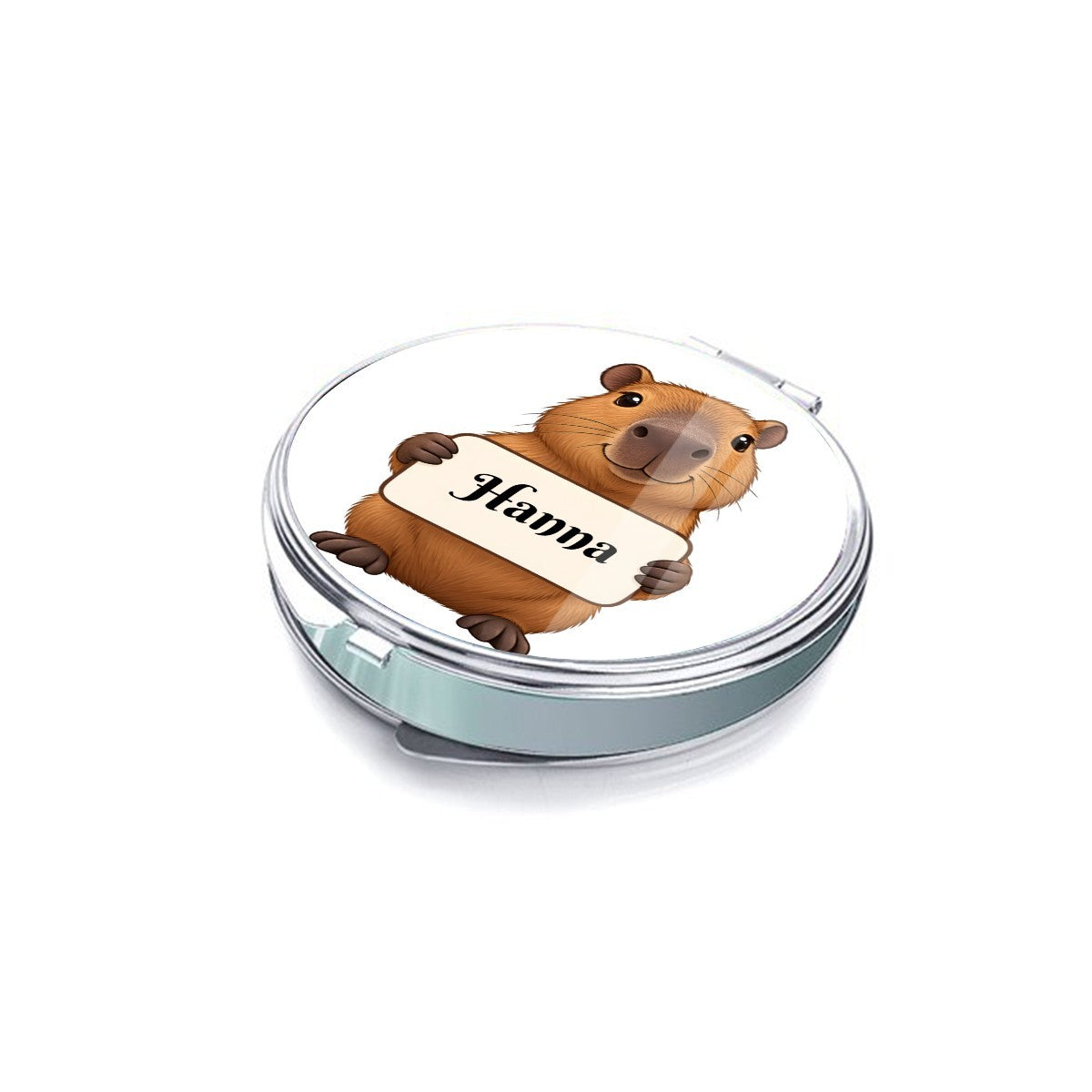 Side view of a round silver compact mirror with capybara cover art