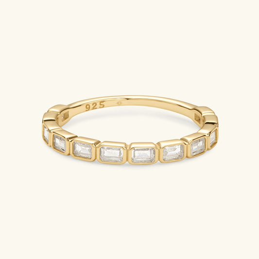 Gold-tone eternity band with rectangular clear-cut stones around the top