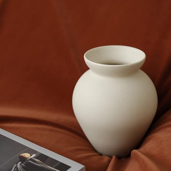 Small cream ceramic milk can vase with matte speckled texture and narrow neck.