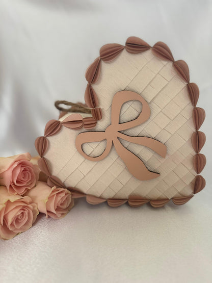 Corazón piñata de tarta San Valentín crema con lazo rosa y borde de hojas