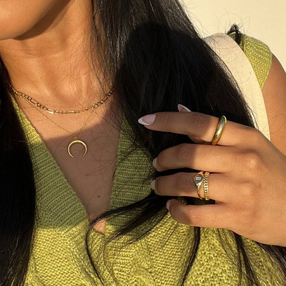 Gold-tone signet ring with small round bezel stone