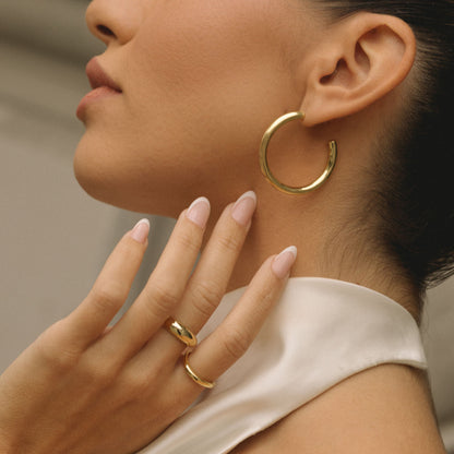 Gold wavy dome ring on finger, smooth curved band with raised wavy top