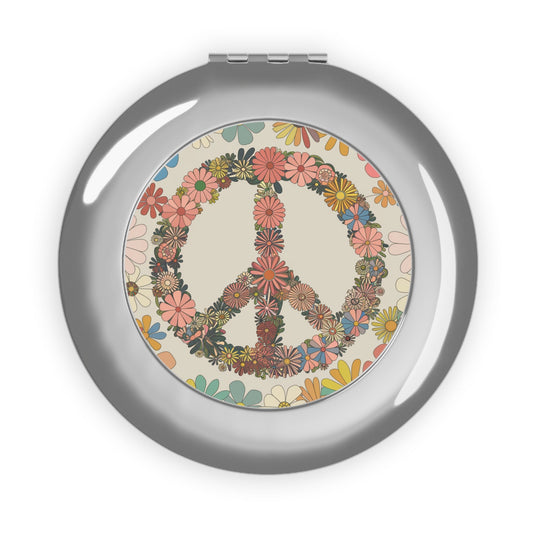 Compact travel mirror with silver glossy frame and peace sign floral design on the glass