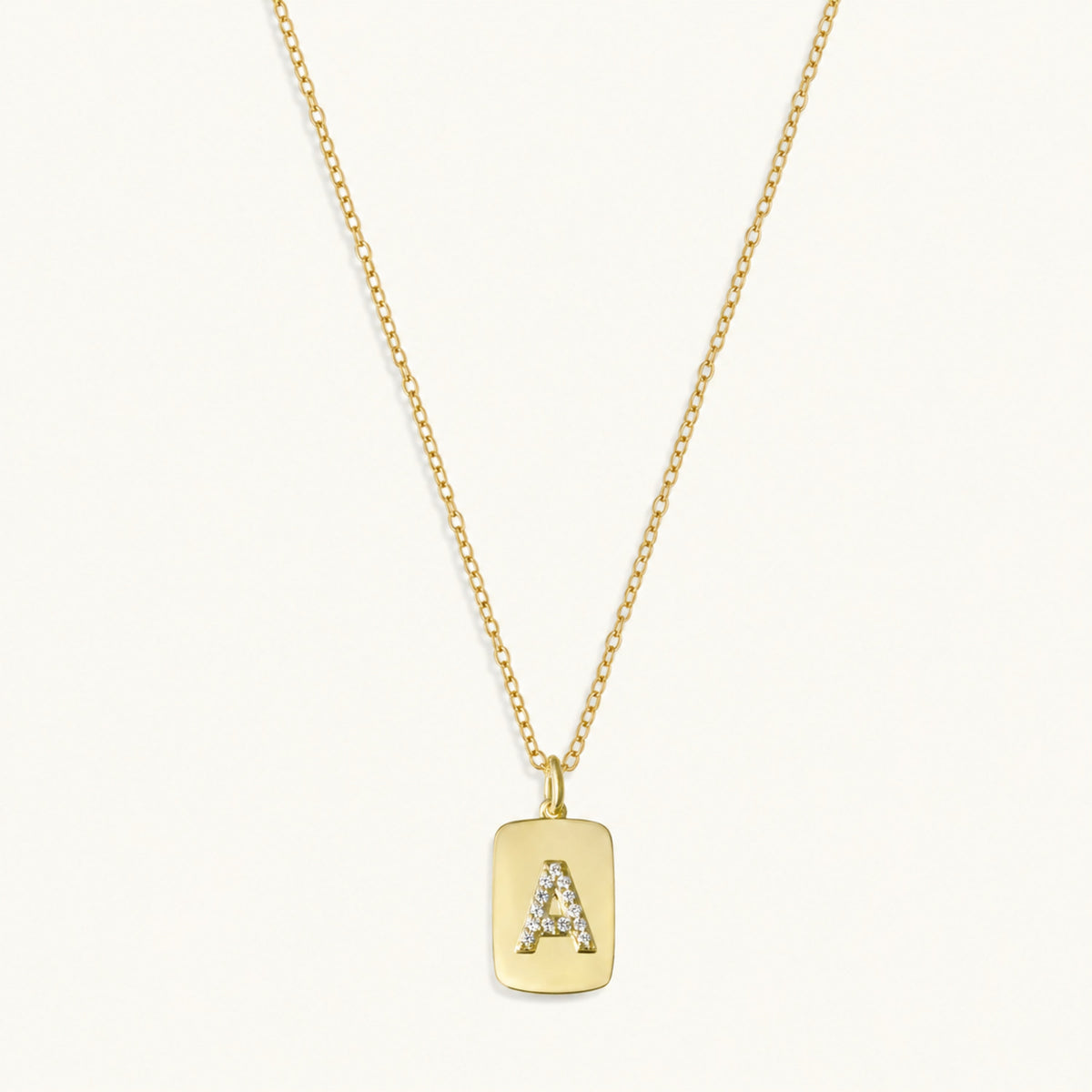 10k gold initial dog tag necklace with raised A charm and sapphire accents