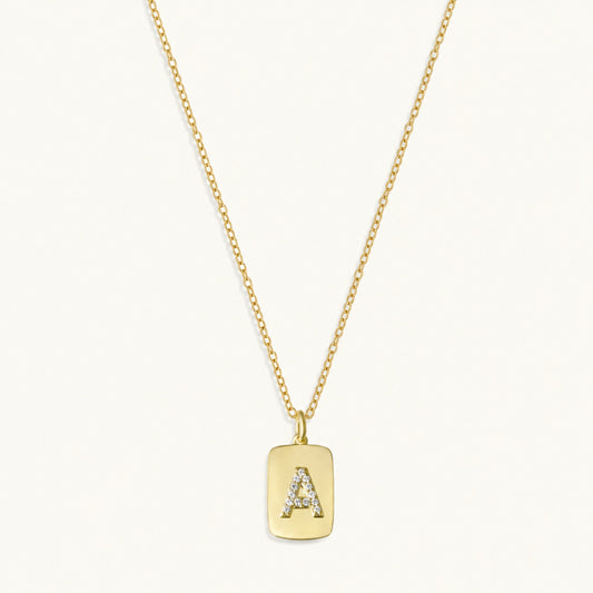 10k gold initial dog tag necklace with raised A charm and sapphire accents