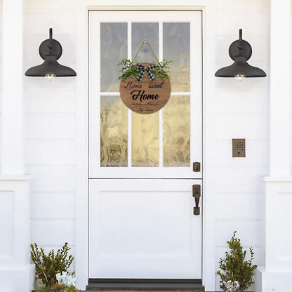 Round wooden “Home Sweet Home” sign with plaid bow, green foliage, personalized lettering