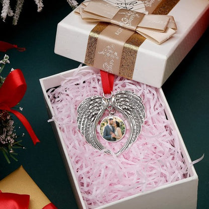 Angel wings heart photo ornament in open gift box with pink shredded insert