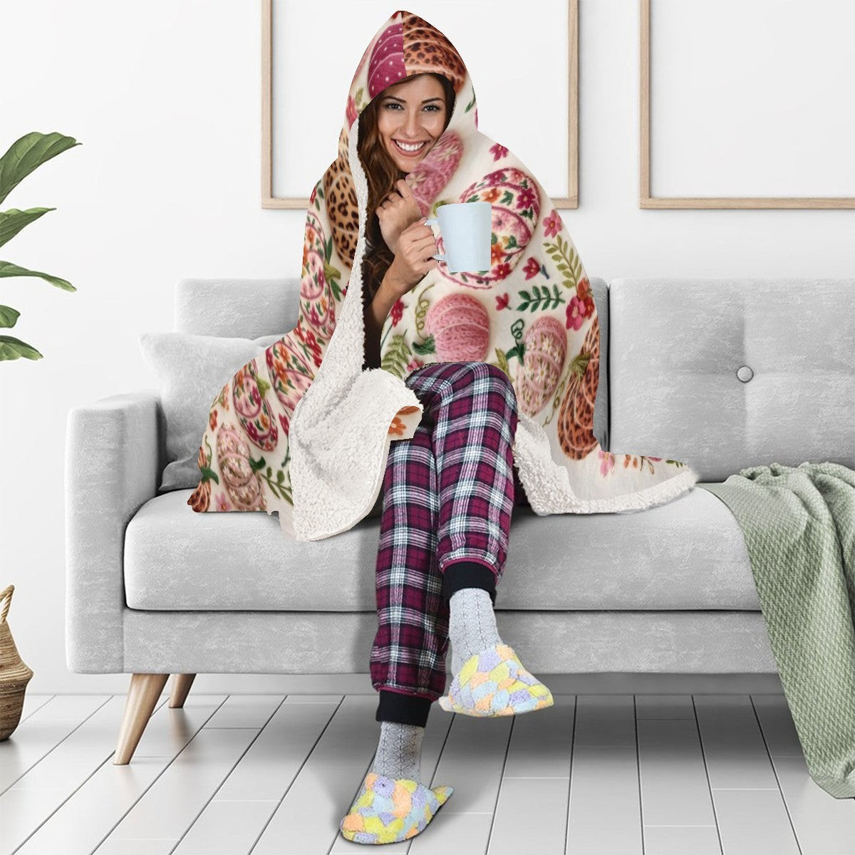 Sherpa-lined hooded blanket with colorful pumpkin pattern, draped over shoulders.