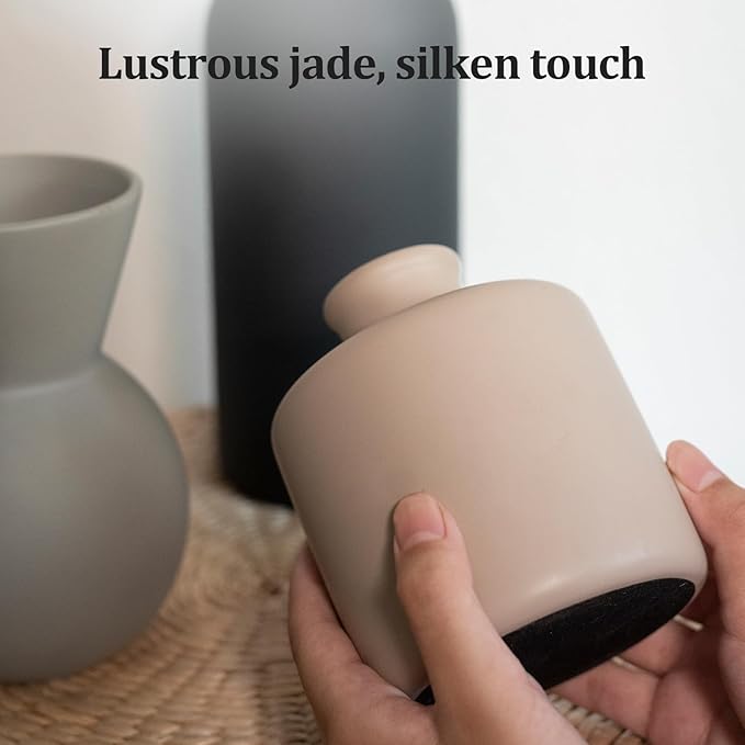Ceramic vase with matte finish in taupe/cream held in hand